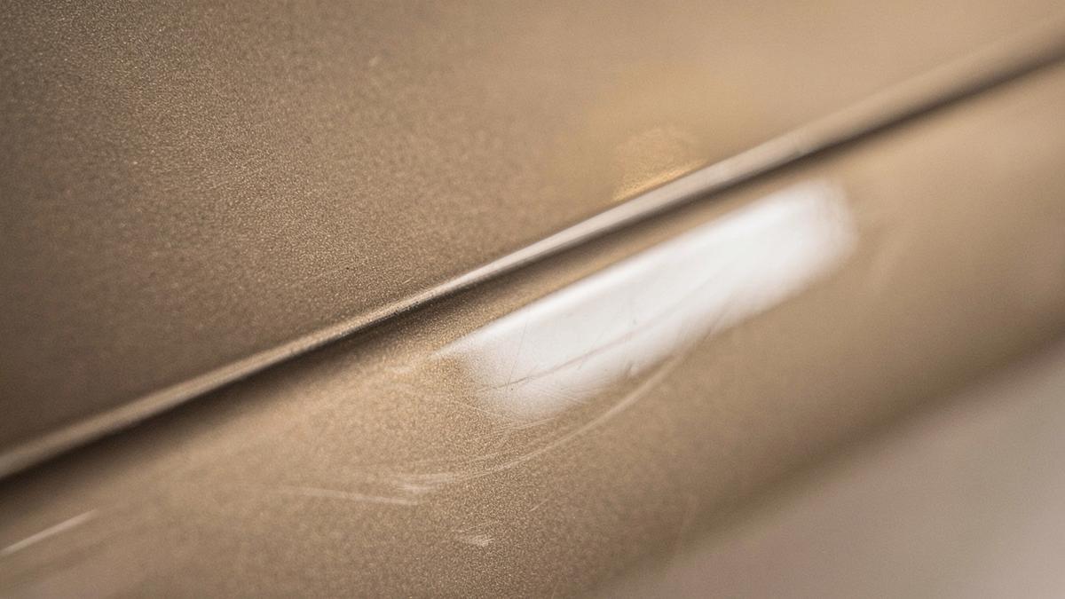 Macro detail of polished paint surface catching studio light