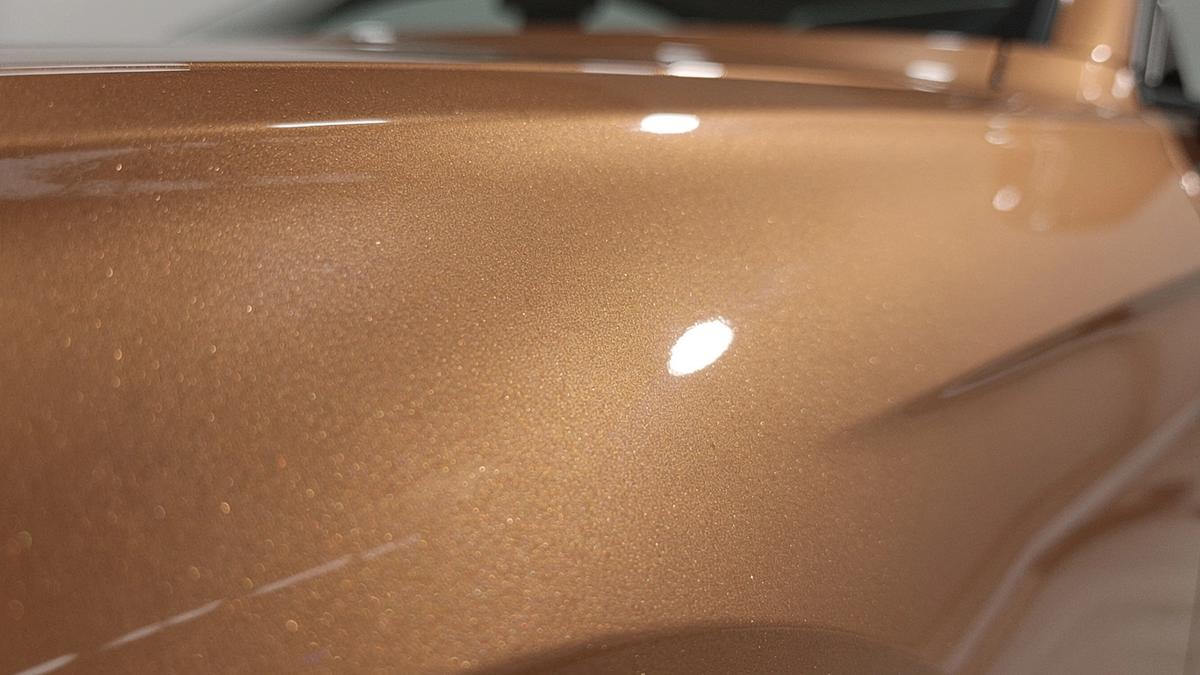 Macro close-up of a coated automotive paint panel catching light